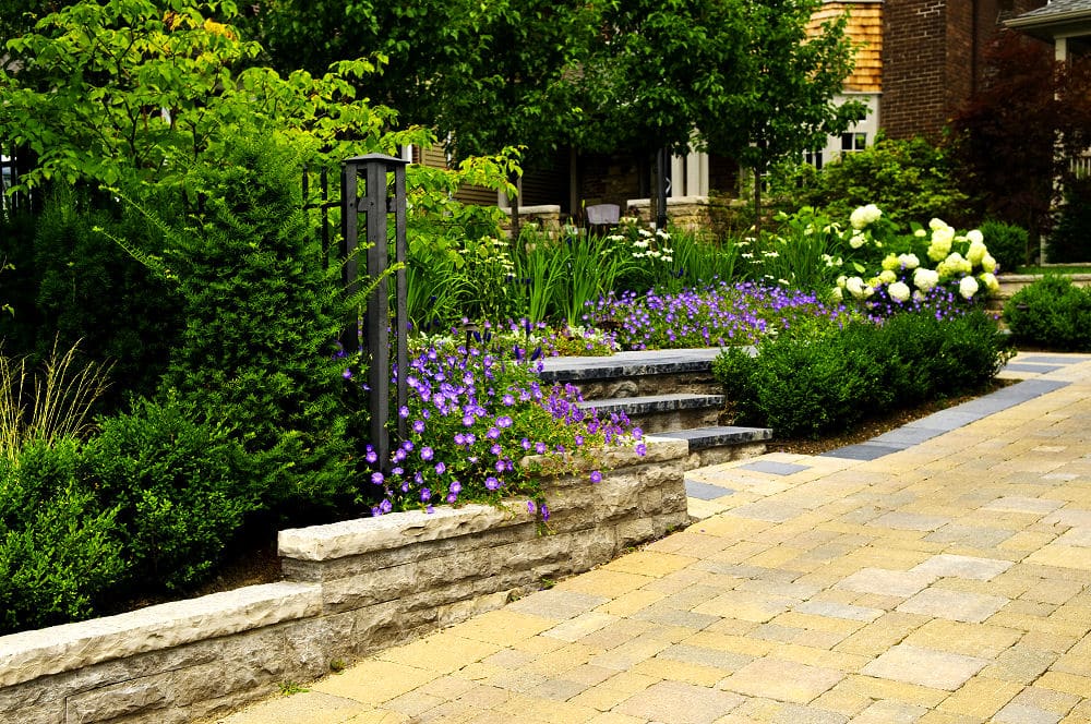 Gartengestaltung mit Beeten, Treppe und einer Zufahrt aus Pflastersteinen