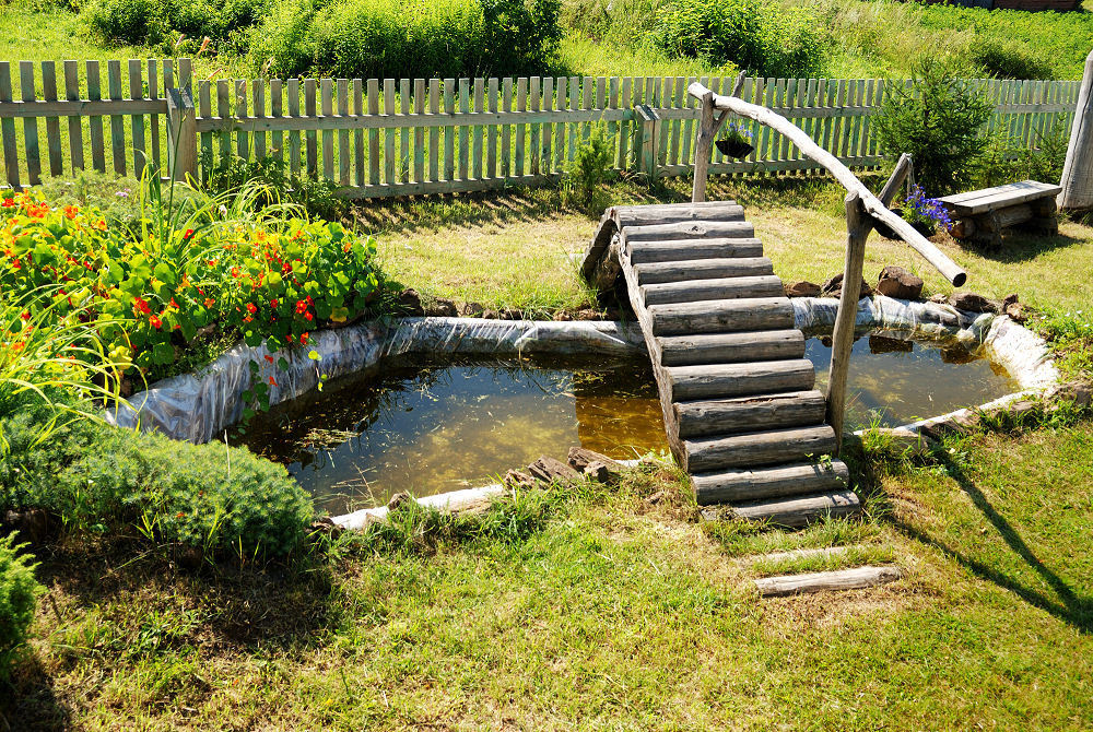 Eine der romantischsten Deko Ideen für den Vorgarten: Ein kleiner Teich mit Kapuziner Kresse und Holzbrücke