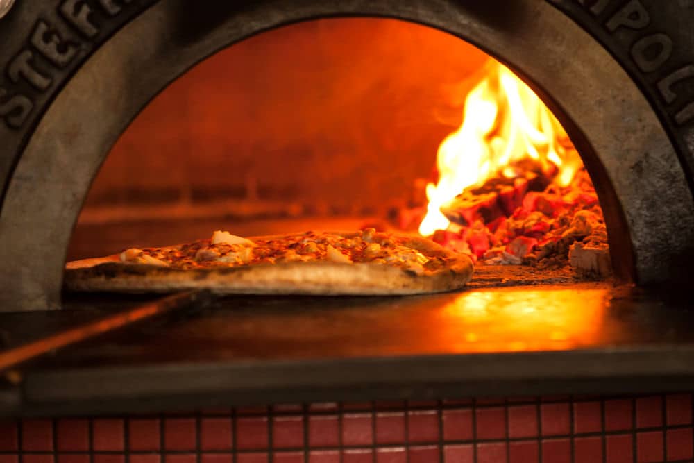 Traditioneller italienischer Pizzaofen in Aktion